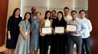 A group of people standing together, holding diplomas