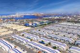 Aerial view of DP World’s Jebel Ali Free Zone in Dubai, showing expansive warehouses, logistics facilities, and the adjacent Jebel Ali Port with cranes and container ships along the waterfront.