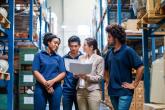 Four person team meeting in a warehouse