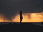 A silhouette of a person stood on a hill