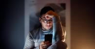 Person looking at smartphone in the dark