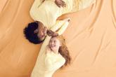 Two models wearing yellow Comfort Colors clothing, lying against a yellow backdrop