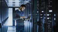 A man in a data center with a laptop.