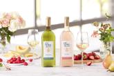 Two bottles of "Bee Lightly" wines with wine glasses and fruit on table
