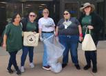 A group of people standing outside with trash bags