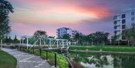 Bridge over water set before apartments at sunset