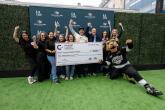 Group stands on a branded step-and-repeat holding a large donation check for the Culinary Careers Program at LA LIVE, with a mascot posing nearby.