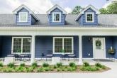 The exterior of a blue house is shown.