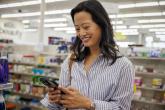 A woman in a CVS using an app on her phone.