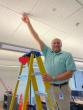 Carl Rohs hanging a red heart from the ceiling.