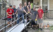 Frank and Shelby shown with Habitat for Humanity volunteers in front of the new ramp at their home.