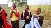 Children smiling while holding different objects