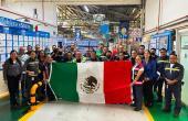 A group of people posed, holding a Mexican flag.