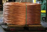 A large bale of coiled copper wire on a pallet in a warehouse.