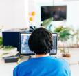 Operator seated behind a desktop computer wearing headphones.