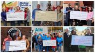 People holding up checks. 