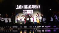 Several young people on stage under a sign reading "Learning Academy: Dakar 2026"