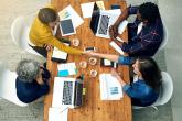group of people working on laptops, viewed from above