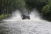 A car driving thorough a flooded street