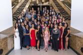 More than 50 people standing at the base of stairs wearing formal attire