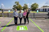 Four people stood together in an electric vehicle charger parking space 