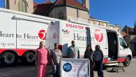 Group photo in front of Heart to Heart van and truck