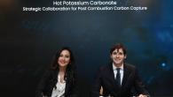 Two smiling business people sitting under the words, "Hot Potassium Carbonate Strategic Collaboration for Post Combustion Carbon Capture"