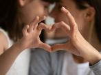 Parent and child making heart shape with hands