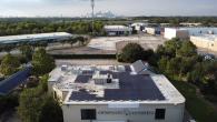 Solar panels on the roof of a building with the Houston skyline in the background
