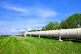 Pipeline in a grassy field with a blue sky
