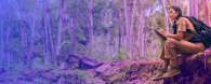 woman writing notes in the forest