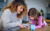 Woman and little girl discussing a lesson about money