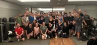 A group posed in a gym