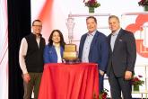 leaders standing around the trophy