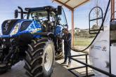 A person refueling a New Holland tractor