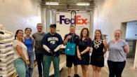 a group standing in front of a FedEx truck