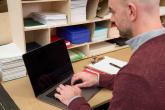 A person seated and in front of a laptop.