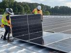 Workers installing solar panels on roof of Southwire's North Campus plant