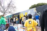 Dozens of volunteers painted a mural featuring the Compton Initiative's motto "Just Do Good."