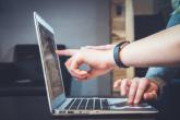 Person touching laptop screen