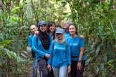 Group of people wearing blue Principal Financial Group shirts in a forest.