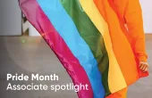 A person holding a rainbow flag. "Pride Month Associate spotlight"