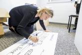 Grant check for $100,00.00 being made out by a representative from Webster Bank.