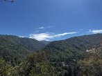 Aerial view of a hilly, forested landscape.