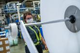 Manufacturing plant manager Karen Crisp on the shop floor looking at equipment 