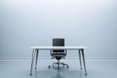 Desk and chair in the center of an empty room