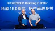 Two people stood together against a blue backdrop 