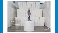 Image of man standing among stack of paper