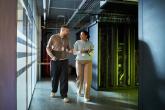 Two workers walking through a data center