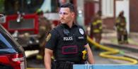 Policeman standing near firefighters on a city street